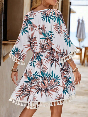 Woman wearing Bella Road Swim tassel tied half sleeve cover up with floral print and tassels, perfect for beach days.