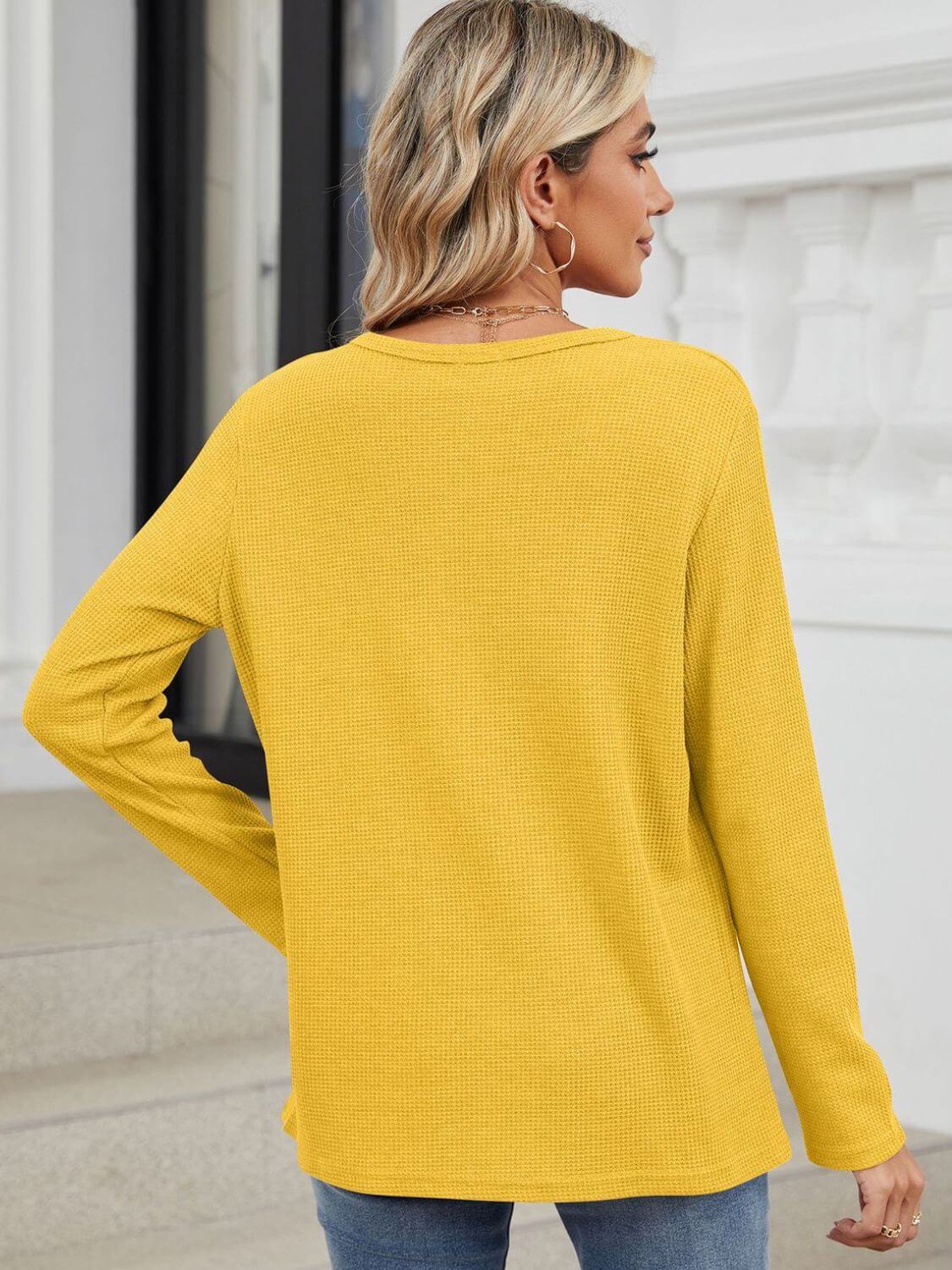 Back view of woman wearing Bella Road waffle-knit notched long sleeve T-shirt in yellow, showcasing casual style and comfort.