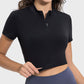 Woman smiling in a black Millennia Quarter Zip Short Sleeve Active T-Shirt, showing versatility and style for workouts.