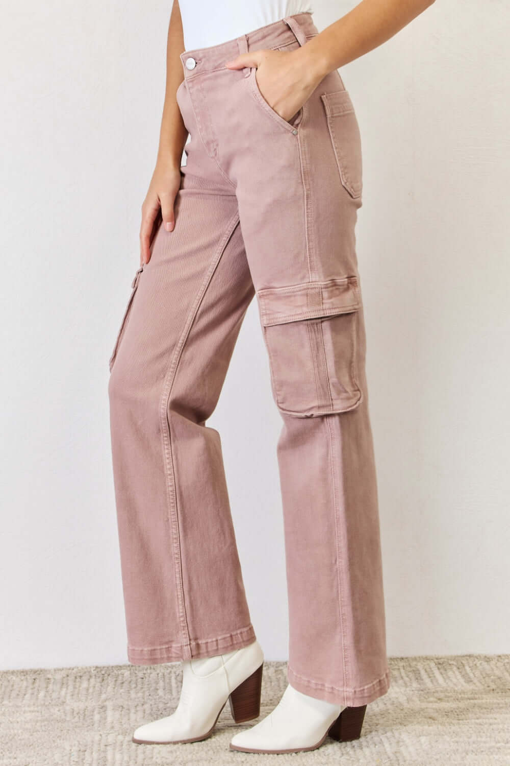 Woman wearing RISEN Full Size High Rise Cargo Wide Leg Jeans in pink, showcasing the high-rise fit and functional cargo pockets.