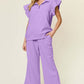 Woman wearing a lavender texture ruffle short sleeve top and drawstring wide leg pants set with pockets, slightly stretchy two-piece outfit.