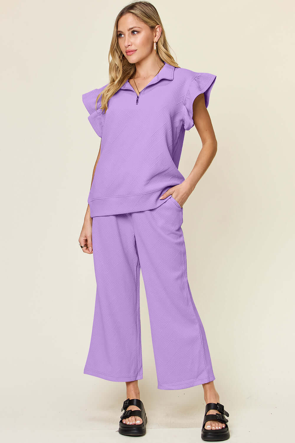 Woman wearing a lavender texture ruffle short sleeve top and drawstring wide leg pants set with pockets, slightly stretchy two-piece outfit.