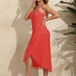 Woman wearing a red backless tassel surplice spaghetti strap cover up dress, standing outdoors against a beige wall.