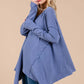 Woman wearing a blue Ces Femme asymmetrical long sleeve top with a relaxed fit and hi-low hem detail, paired with jeans.