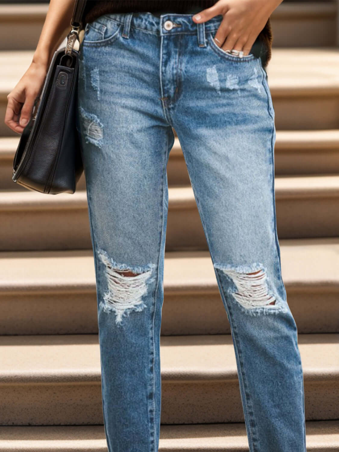 Woman wearing distressed raw hem jeans with pockets, featuring slightly stretchy material for a comfortable fit.