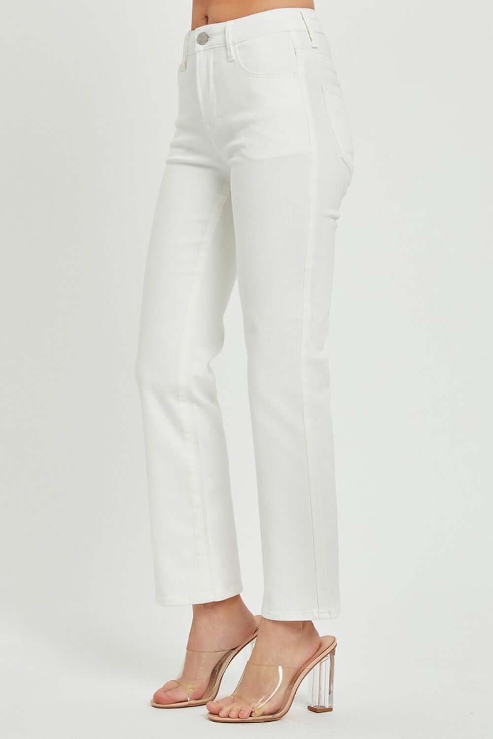 RISEN mid rise bootcut jeans with pockets in white, styled with clear heels for a chic and fashionable look.