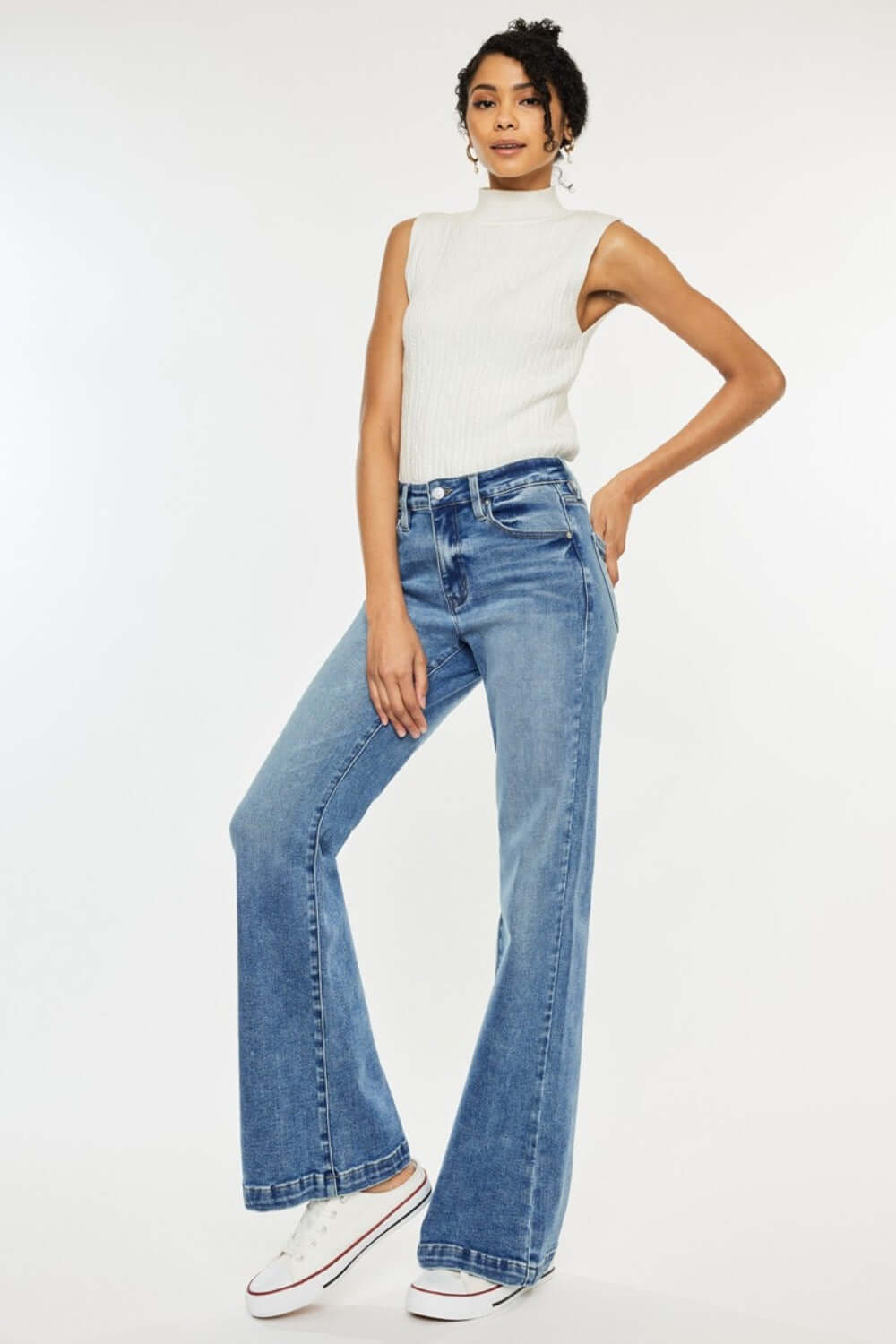 Woman wearing Kancan high-rise wide leg jeans in medium wash with a white top, showcasing stylish comfort and modern flair.