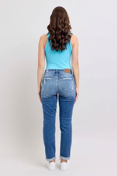 Model showcasing Judy Blue distressed jeans, back view, featuring button fly and pockets, perfect for casual outings.