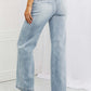 Woman wearing Luisa Wide Flare Jeans by Risen Jeans, showcasing high waist and wide flare design with functional back pockets.