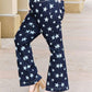 Woman wearing Janelle Full Size High Waist Star Print Flare Judy Blue Jeans with dark wash and star design.