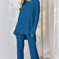 Woman wearing a blue ribbed high-low top and wide leg pants set made of slightly stretchy polyester-elastane blend, perfect for casual wear.