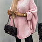 Woman wearing pink Bella Road Round Neck Batwing Sleeve Sweater, holding a quilted black handbag.