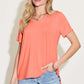 Woman wearing coral Bamboo V-Neck High-Low T-Shirt paired with light blue jeans, featuring slightly stretchy fabric and basic style.