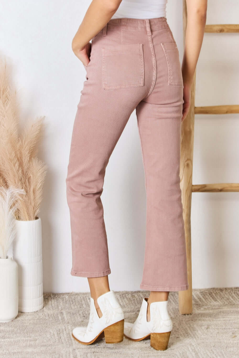 High Rise Ankle Flare Jeans by Risen Jeans in a blush hue, pocketed and slightly stretchy, offering a flattering fit and modern silhouette.