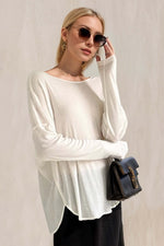 Woman wearing Basic Bae High-Low Long Sleeve T-Shirt in white, paired with sunglasses and a chic black handbag.