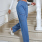 Woman wearing Bella Road High Waist Straight Leg Jeans with Pockets, styled with a white crop top and sneakers, walking upstairs