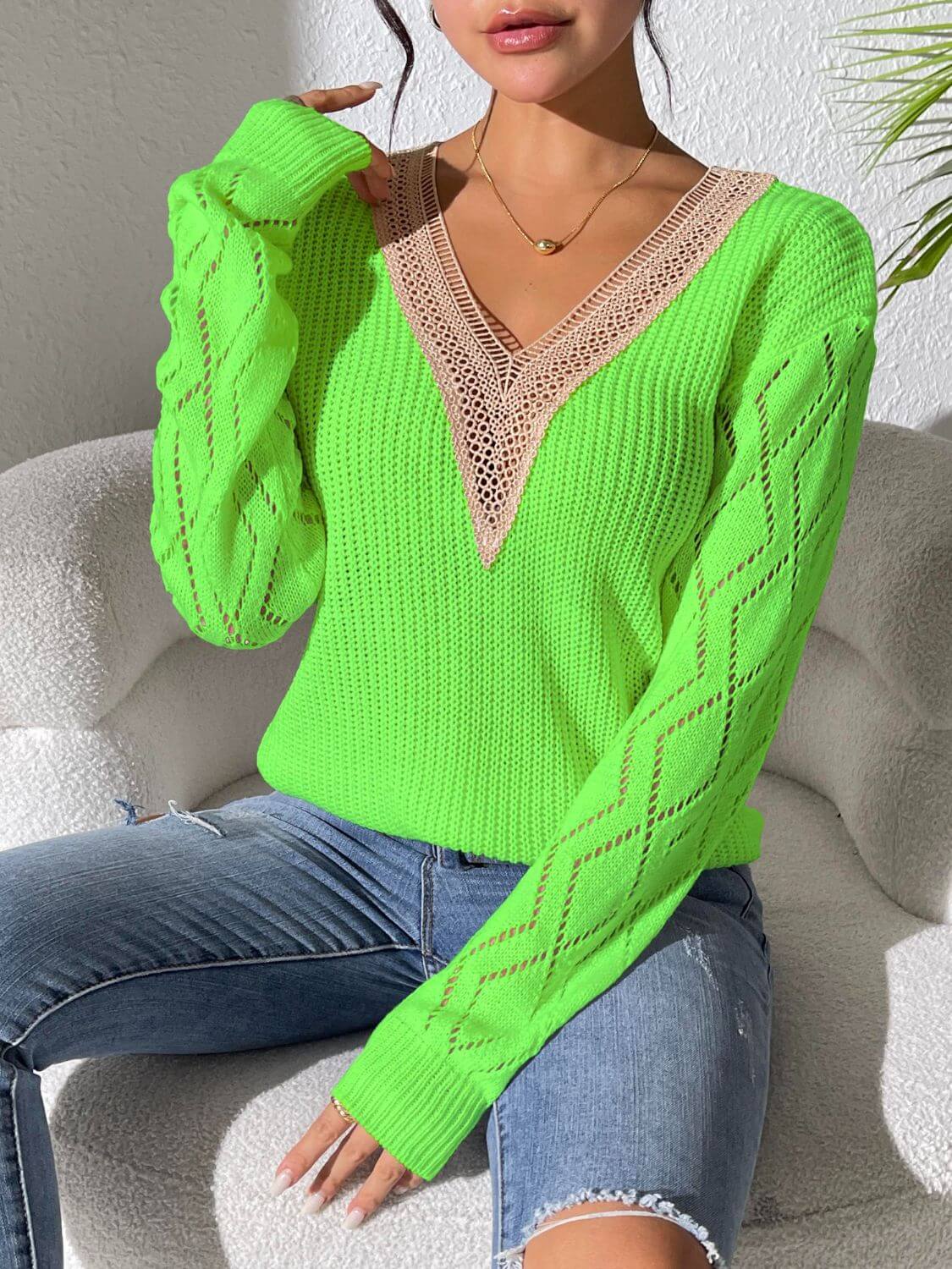 Bright green v-neck sweater with openwork design and long sleeves, perfect for a stylish and cozy look.