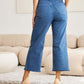 Woman wearing Crop Chloe Tummy Control High Waist Raw Hem Jeans paired with heels, highlighting the back view.