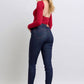 Woman in red top wearing Judy Blue Heart Shaped Back Pockets Skinny Jeans, showcasing stylish back pocket detail.