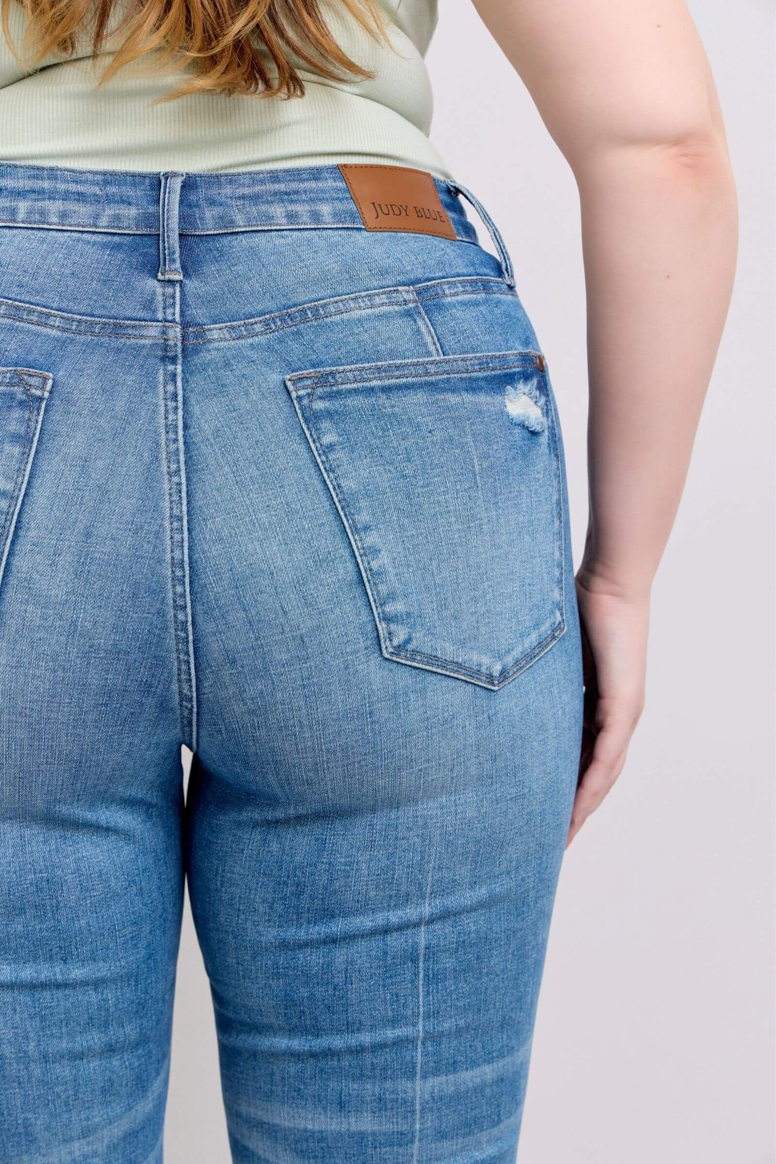 Back view of Judy Blue high waist vintage wash jeans showcasing tummy control and a stylish, flattering fit.