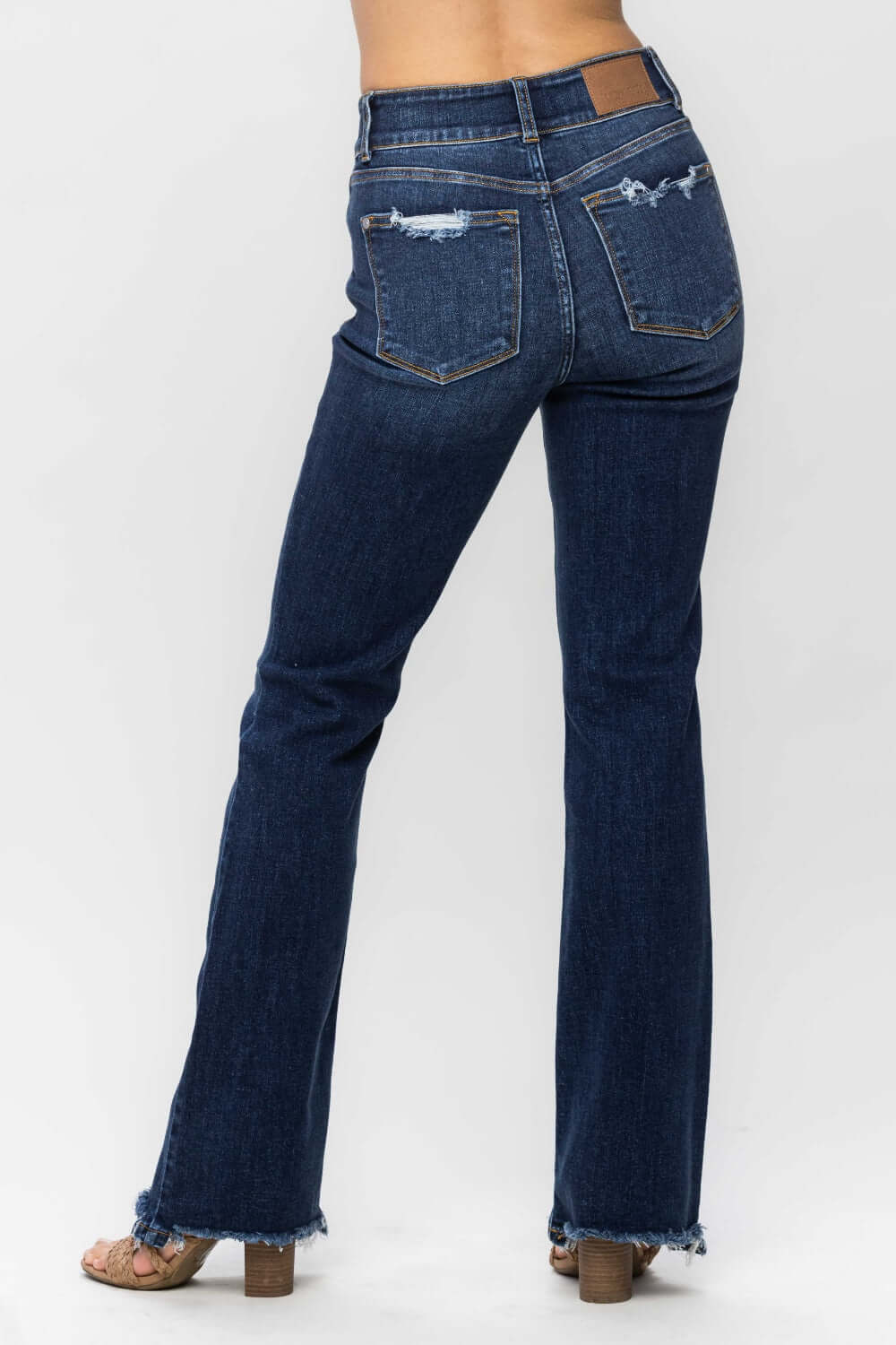 Frayed hem bootcut jeans by Judy Blue Jeans with distressed back pockets and a flattering silhouette.