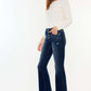 Woman wearing Kancan mid-rise button fly flare jeans with white top and sneakers.