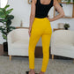 Woman wearing FAM-FAM high waist skinny pants in yellow, showcasing stylish versatility for effortless fashion.