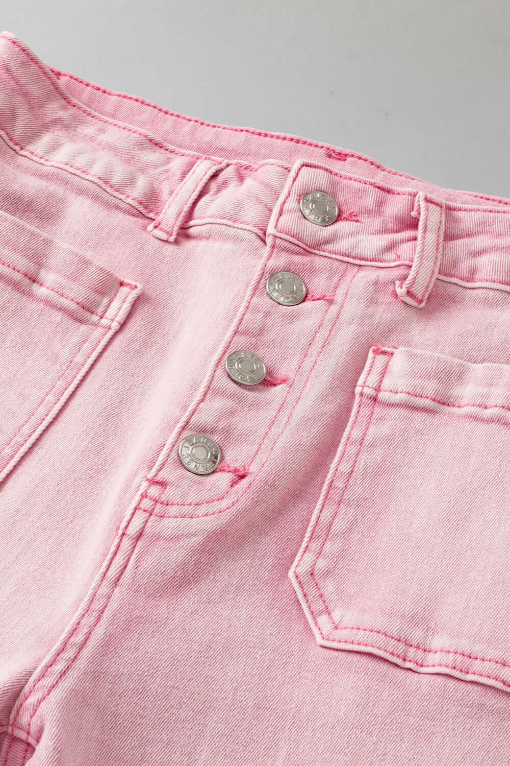 Pink raw hem button-fly jeans with pockets perfect for petites, made of 98% cotton and 2% elastane, no stretch. Machine wash cold.