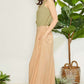 Woman wearing Wrap Pleating Detail Wide Leg Pants in neutral color, styled with a green top, perfect for modern and elegant look