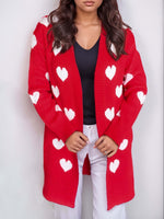 Woman wearing Bella Road Heart Open Front Long Sleeve Cardigan with white heart patterns and black top.