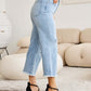 Woman wearing RFM Jeans Tummy Control High Waist Raw Hem Distressed Jeans in a stylish setting.