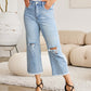 Woman wearing RFM Jeans Tummy Control High Waist Raw Hem Distressed Jeans in a stylish setting.