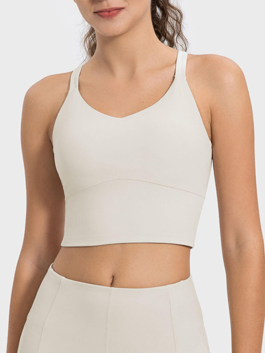 Millennia Crisscross Round Neck Active Tank in light beige, showcasing comfortable fit and sleek design for activewear lovers.