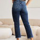 Woman wearing Crop Dylan Full Size Tummy Control Distressed High Waist Raw Hem Jeans from RFM Jeans, showcasing back view.