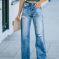 Woman wearing distressed straight leg jeans with no stretch, 65% cotton and 35% polyester, holding a clutch purse.