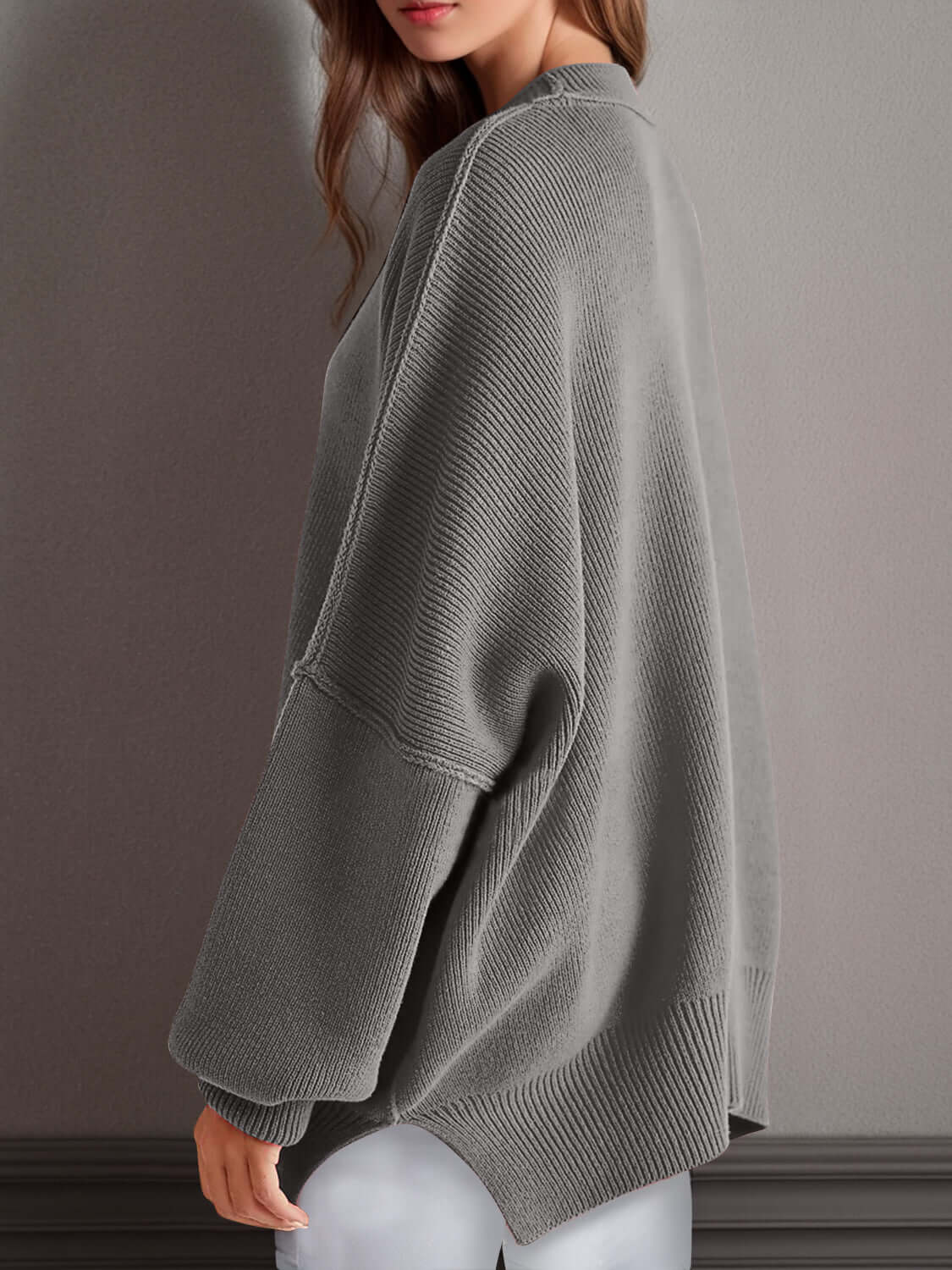 Woman wearing gray Double Take Side Slit Round Neck Long Sleeve Sweater with a playful side slit design.