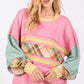 Woman wearing a Mineral Wash Raw Edge Color Block Sweatshirt with plaid print long sleeves and a bold, eye-catching design.