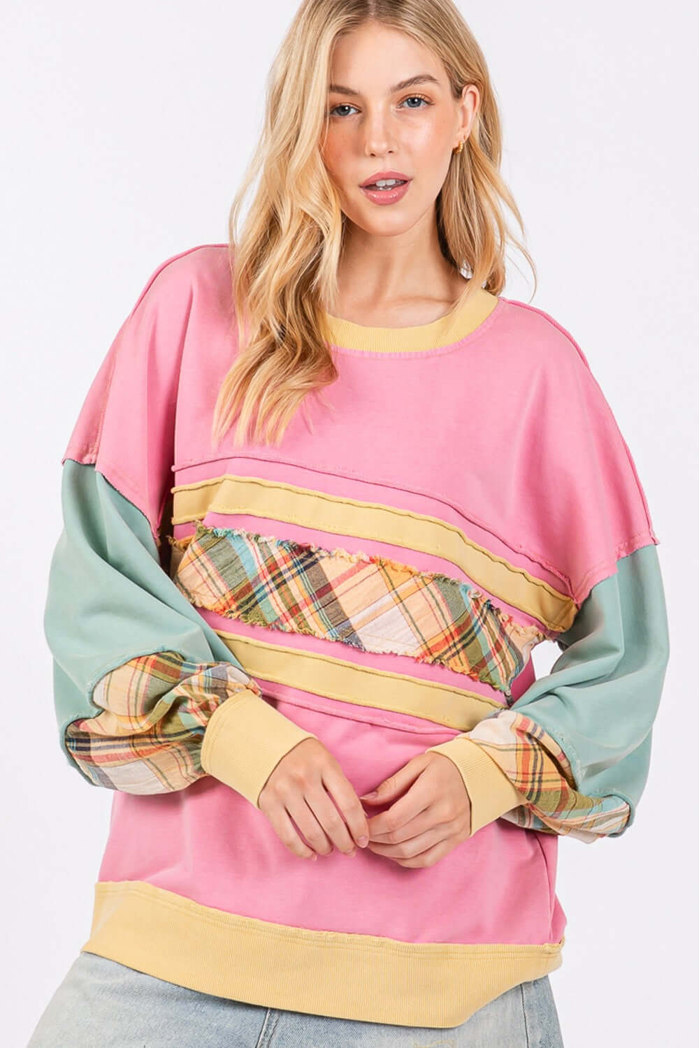 Woman wearing a Mineral Wash Raw Edge Color Block Sweatshirt with plaid print long sleeves and a bold, eye-catching design.