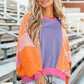 Woman wearing Bella Road Color Block Round Neck Long Sleeve Top with trendy design, standing on outdoor steps.