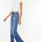 Model wearing Ultra High Waist Gradient Flare Jeans with a chic white top and beige heels. Stylish and trendy denim look.