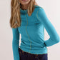 Model wearing a Basic Bae Contrast Trim Mock Neck Long Sleeve T-Shirt in turquoise with a wavy trim.