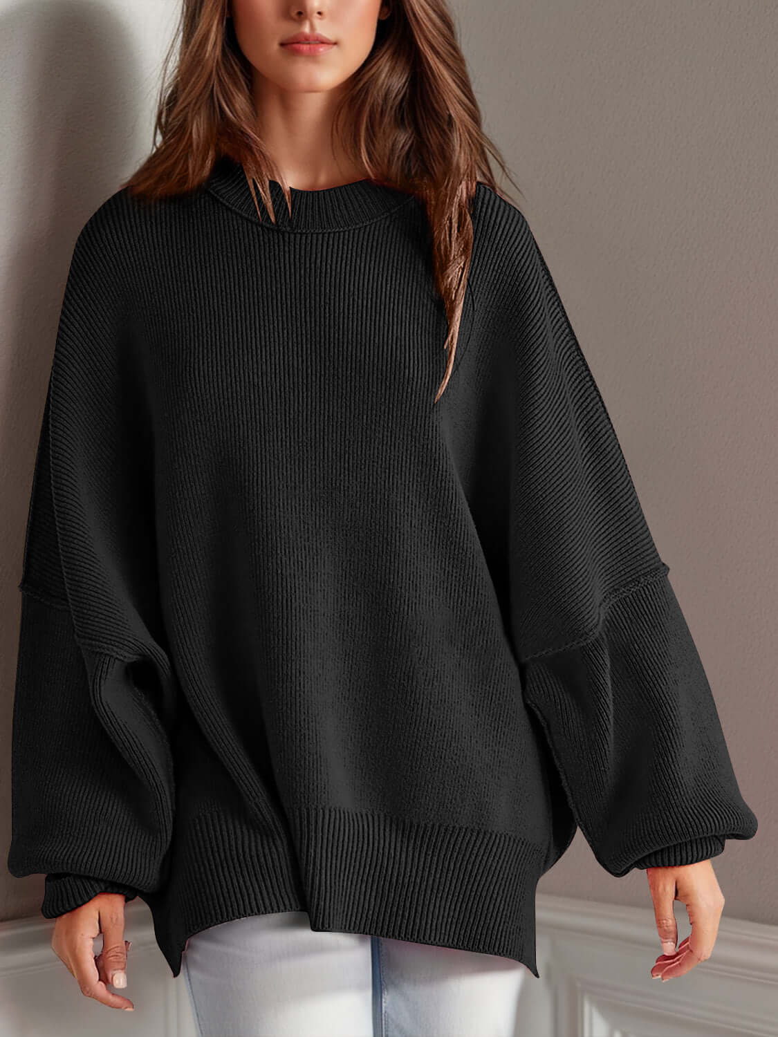 Woman wearing black Double Take Side Slit Round Neck Long Sleeve Sweater featuring a cozy, playful side slit design.