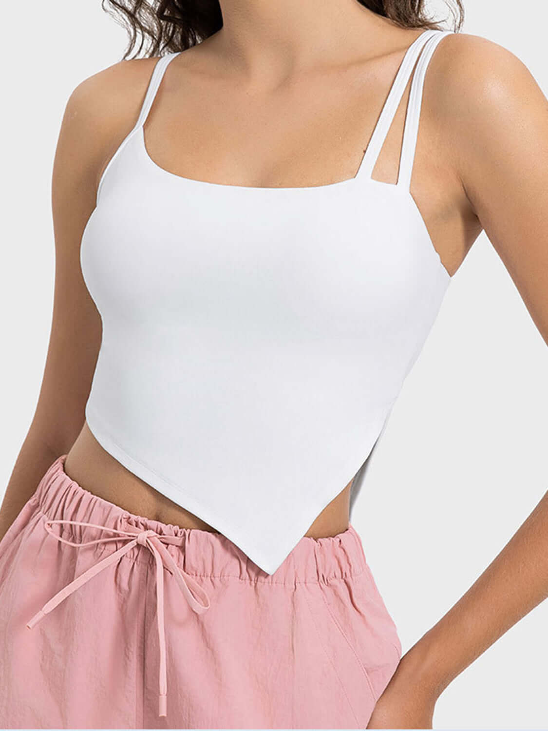 Stylish white asymmetrical neck active cami paired with pink lounge shorts, perfect for workouts and casual outings.