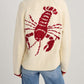 Woman wearing Bella Road Lobster Button Up Long Sleeve Cardigan with playful red lobster design on the back.