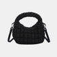 Black quilted puffy crossbody bag with a removable strap, versatile design for use as a clutch, perfect for any occasion.