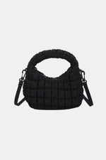 Black quilted puffy crossbody bag with a removable strap, versatile design for use as a clutch, perfect for any occasion.