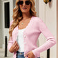 Woman wearing Bella Road Button Up Long Sleeve Cardigan in pink, paired with sunglasses, white top, and jeans, standing outdoors.