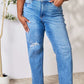 Plus-size model wearing high waist distressed jeans by Judy Blue Jeans in medium blue, showcasing the comfortable and stylish fit.