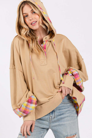 Full size plaid print washed hoodie with adjustable drawstring, plaid accents on hood and cuffs, worn by woman standing casually in ripped jeans.