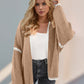 Stylish woman wearing a beige Double Take Contrast Open Front Cardigan with dropped shoulders.